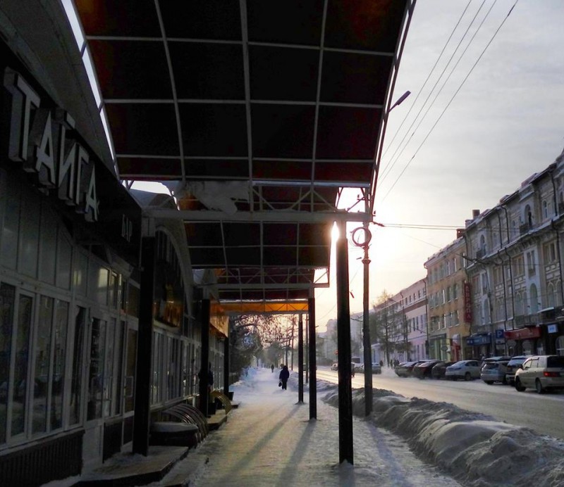 Omszki utcakép egy téli reggelen, a bal szélen stílusosan a Tajga bár logójával